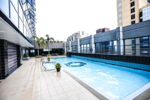 a large swimming pool on the side of a building at The Malayan Plaza Hotel in Manila