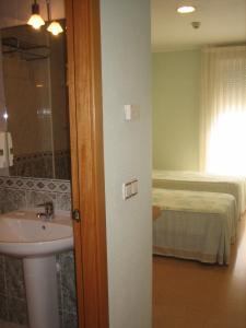 a bathroom with a sink and a bed at Hostal Madruga in Elche