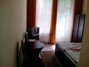 a bedroom with a bed and a desk and a tv at Albatros in Świnoujście
