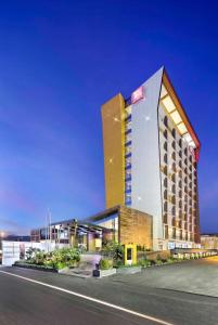 Ibis Padang في بادانج: فندق ذو مبنى طويل امام شارع