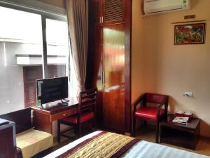 a bedroom with a bed and a desk with a computer at Hong Ky Boutique Hotel in Diện Biên Phủ