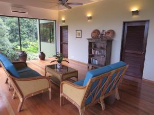 een woonkamer met stoelen en een tafel bij Nanga Damai Homestay in Santubong