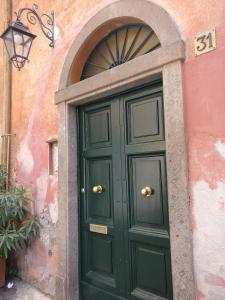 ローマにあるScent Of Trastevereの上の看板の緑の扉