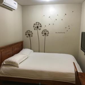 a bedroom with a bed with dandelions on the wall at Se One Hotel in Butterworth
