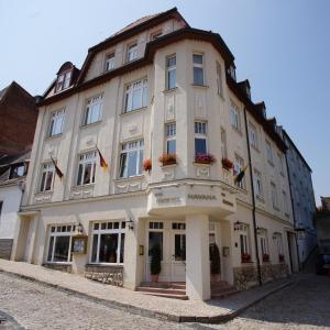 a large white building on a cobblestone street at Hotel Fürsteneck in Bernburg