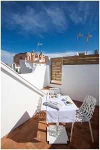 a balcony with a table and chairs on a roof at Cheap & Chic Hotel in Ciutadella