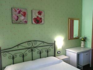 ヴィエステにあるB&B Villa Makkalèのベッドルーム1室(ベッド1台付)、壁に鏡と花を飾っています。