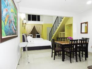 uma sala de jantar com uma cama, uma mesa e cadeiras em Wadi Iman Guesthouse @ i-City em Shah Alam