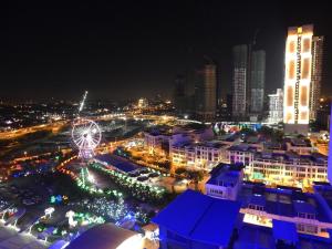 una vista de la ciudad por la noche con una noria en Wadi Iman Guesthouse @ i-City en Shah Alam