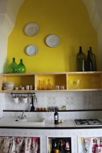 a kitchen with green glass vases on the wall at Villa Colittacarrafa in Galatone