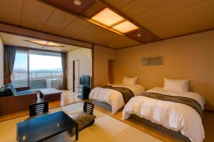 um quarto de hotel com duas camas e uma televisão em Biwako Ryokusuitei em Otsu