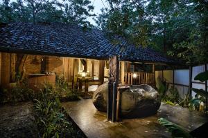 een huis met een grote rots ervoor bij Desa Alamanis Resort Vila in Cirebon