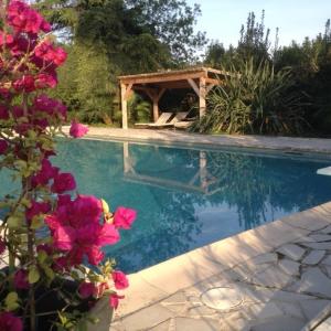 einen Pool mit einem Pavillon und rosa Blumen in der Unterkunft Le Clos de St Paul in La Colle-sur-Loup