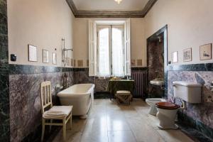 La salle de bains est pourvue d'une baignoire, de 2 toilettes et d'un lavabo. dans l'établissement Villa Cernigliaro Dimora Storica, à Sordevolo