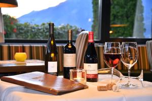 a table with three bottles of wine and two glasses at Hotel Klarnerhof in Schenna