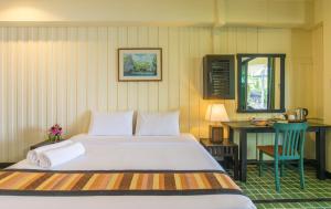 a bedroom with a bed and a desk with a chair at Krabi City Seaview Hotel in Krabi