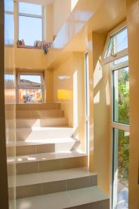 a staircase in a house with two windows at Sakura Guesthouse in Bishkek