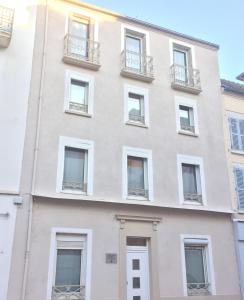 an apartment building with white windows and balconies at Résidence des Sources in Vichy