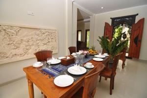 a dining room with a wooden table and chairs at Kandava Villa in Jimbaran