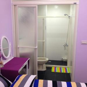 a purple bathroom with a toilet and a shower at Jiufen Golden House in Jiufen