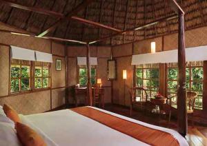 a bedroom with a large bed and a dining room at The Barefoot At Havelock in Havelock Island