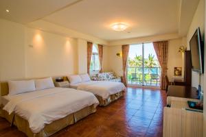 Habitación de hotel con 2 camas y TV en Aquamarine Cottage en Fushan