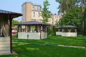two gazebos in a park in front of a building at City Holiday Resort & SPA in Kyiv