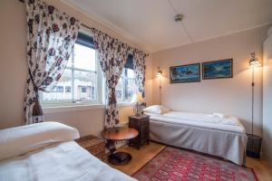 a bedroom with two beds and a window at Mary-Ann's Polarrigg in Longyearbyen