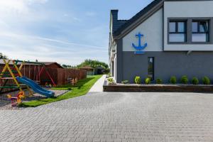 a house with a playground with a slide at Apartamenty Kormoran in Sarbinowo