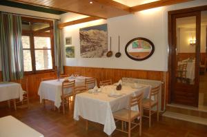 a dining room with tables and chairs and a large window at Hotel Vall Ferrera in Areu