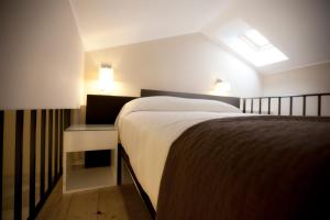 バロ・デ・リャネスにあるApartamentos Áncoraのベッドルーム1室(大型ベッド1台、ナイトスタンド、ランプ2つ付)