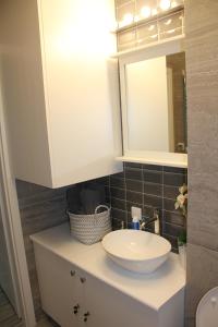 a bathroom with a white sink and a mirror at Apartament Justyna in Stegna