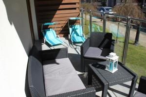 dwa krzesła i stół na balkonie w obiekcie Apartament Justyna w Stegnie