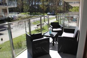 a balcony with chairs and a table and a view of a street at Apartament Justyna in Stegna