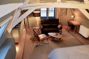 a room with a bed and a couch and a table at B&B Huis Koning in Bruges
