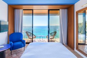 1 dormitorio con cama y vistas al océano en Hôtel Le Bailli De Suffren en Rayol-Canadel-sur-Mer