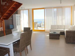 - un salon avec un canapé, une table et des chaises dans l'établissement Apartamentos Ambar Beach Unitursa, à Calp