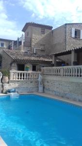 a large blue swimming pool in front of a house at Le Saint Victor in Mirabel-aux-Baronnies