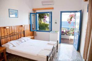 a bedroom with a bed and a large window at Hotel Hariklia in Agia Galini