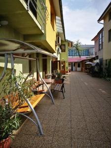 an empty courtyard of a building with tables and benches at Pensiunea Silvia in Baile Felix +18 photos