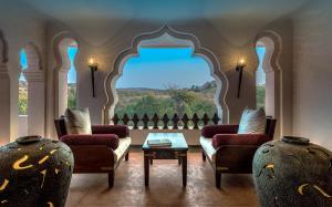 a living room filled with furniture and a large window at Evolve Back Hampi in Hampi