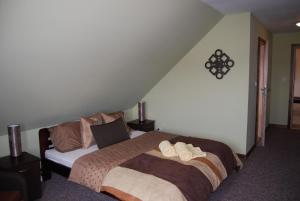 a bedroom with a large bed and a staircase at Kamienna Zagroda in Białowieża