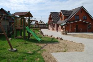 a playground with a slide in a residential neighborhood at Kamienna Zagroda in Białowieża