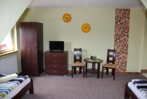 a bedroom with a bed and a table and chairs at Kamienna Zagroda in Białowieża