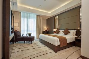 a hotel room with a large bed and a desk at Mandarina Colombo in Colombo