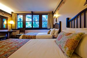 a bedroom with a large bed and a large window at Disney's Sequoia Lodge® in Coupvray