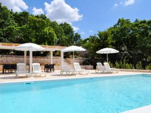 een groep stoelen en parasols naast een zwembad bij B&B Lamie Di Olimpia in Locorotondo