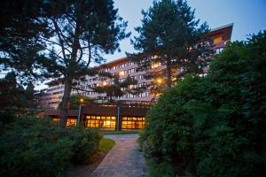 un grand bâtiment avec des lumières allumées devant lui dans l'établissement Disney Sequoia Lodge, à Coupvray