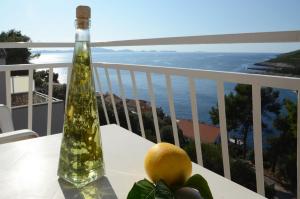 a bottle and fruit on a table on a balcony at Apartments Marijana in Zavalatica