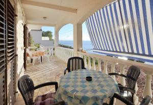 a table and chairs on a balcony with the ocean at Apartments Marijana in Zavalatica